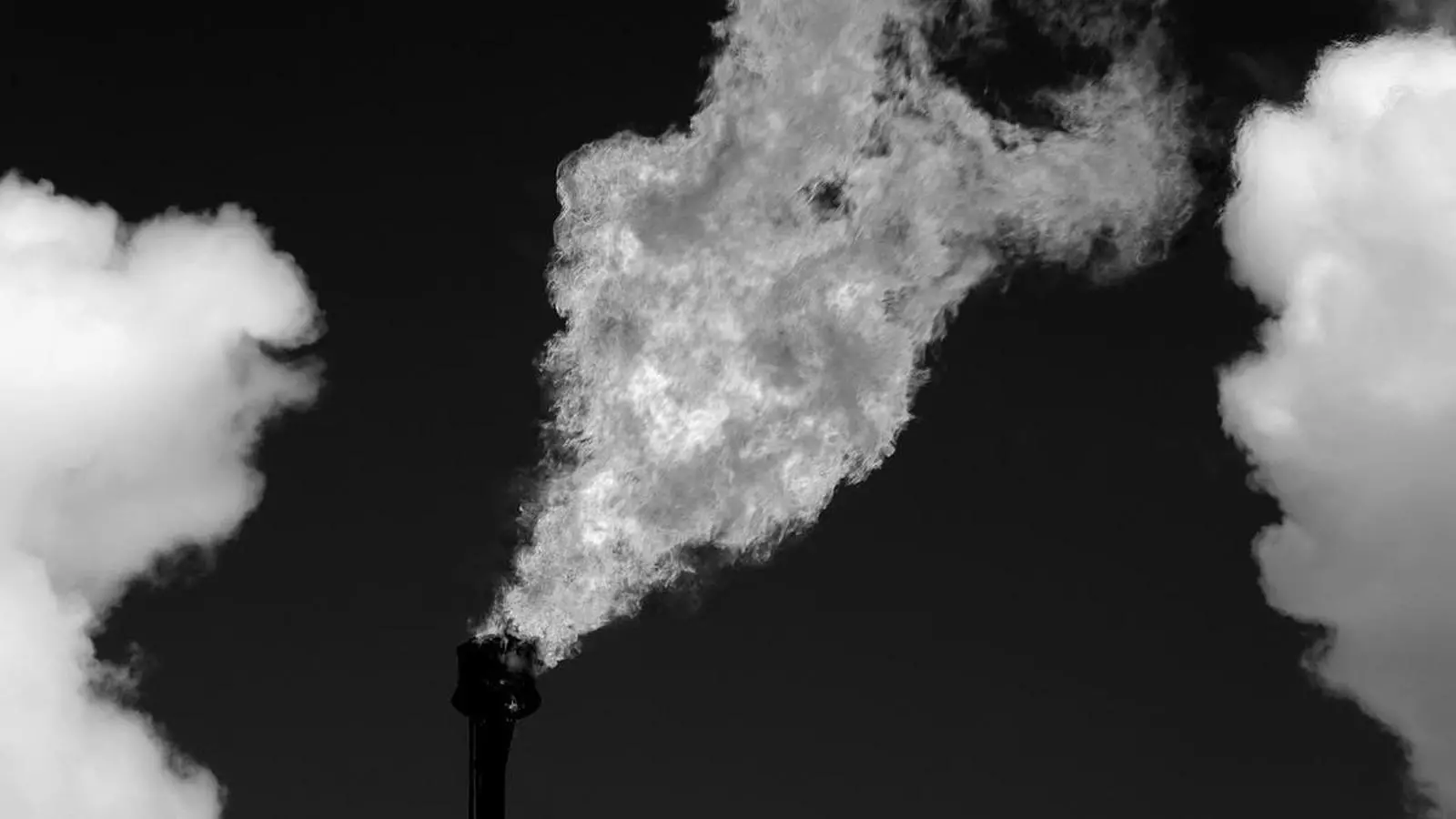 Una fábrica emitiendo humo.