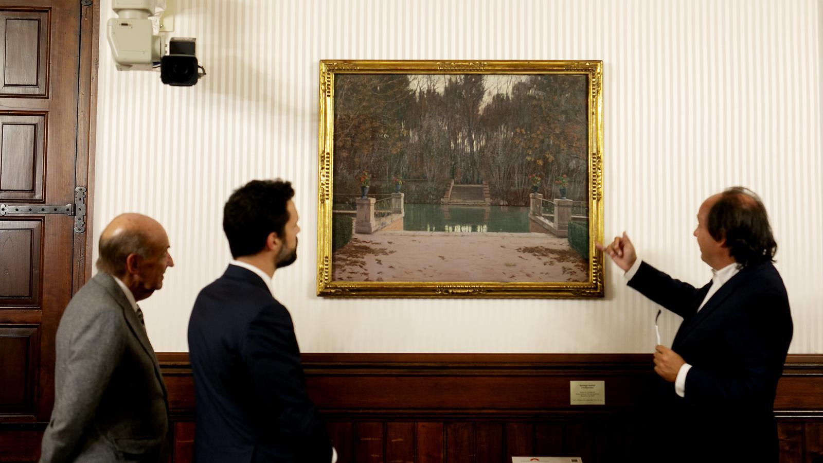 Pepe Serra (a la dreta) explica els detalls de 'L'embarcador', de Santiago Rusiñol a el president del Parlament, Roger Torrent, i al del Museu Nacional d'Art de Catalunya, Miquel Roca