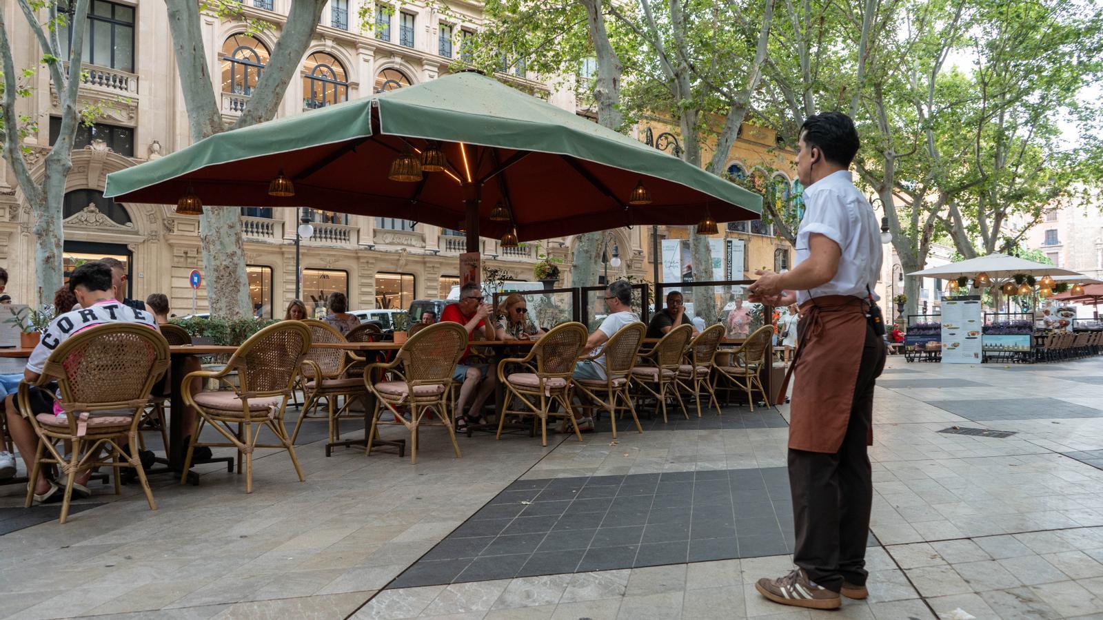 Un trabajador durante su jornada laboral en una terraza en el Born, Palma.