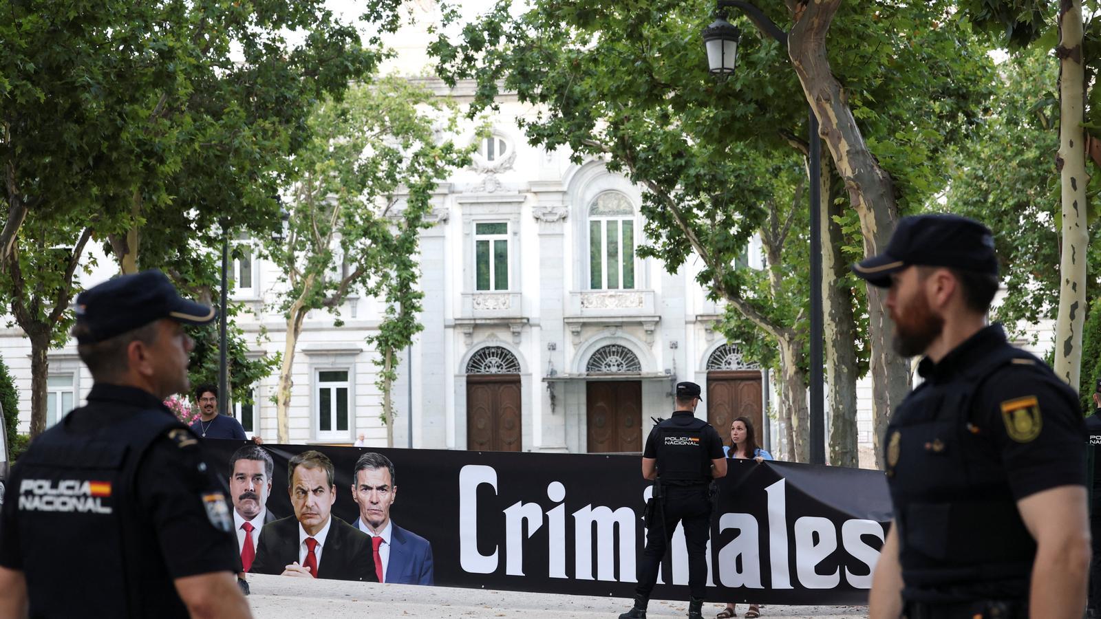 Una pancarta con la palabra 'Criminales' en las puertas de la Audiencia Nacional, poco tiempo antes de la llegada de José Luis Rodríguez Zapatero