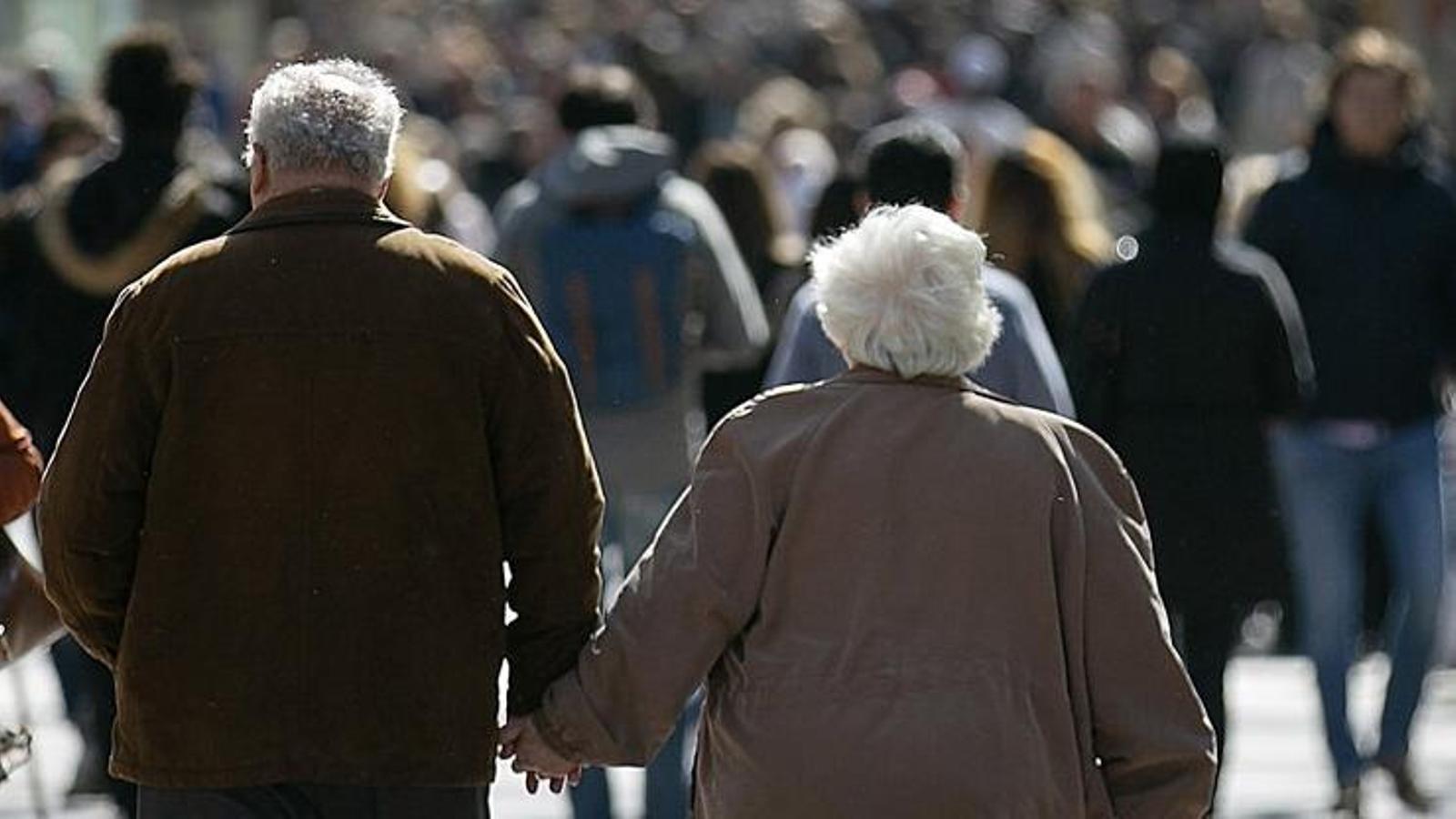 An elderly couple walking down the street.