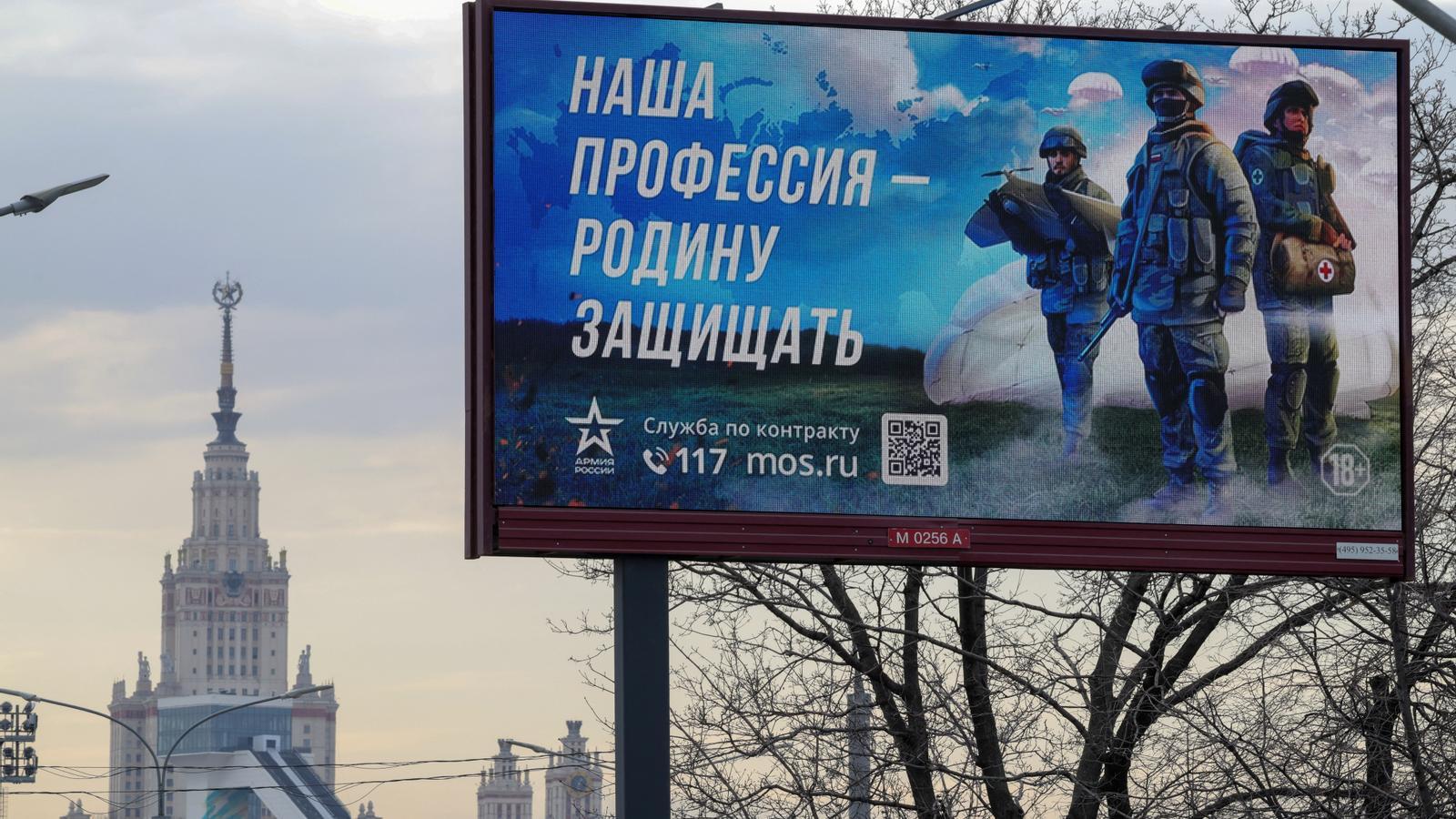 Cartel que promueve el servicio militar en las Fuerzas Armadas de Rusia, frente al edificio principal de la Universidad Estatal de Moscú, con el lema "Nuestra profesión es defender la patria".