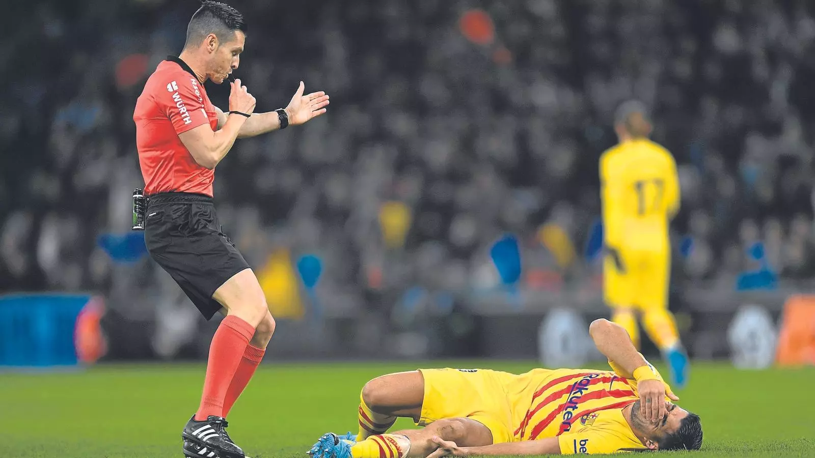 Luis Suárez, estirat al terra després de rebre una entrada en el derbi contra l'Espanyol