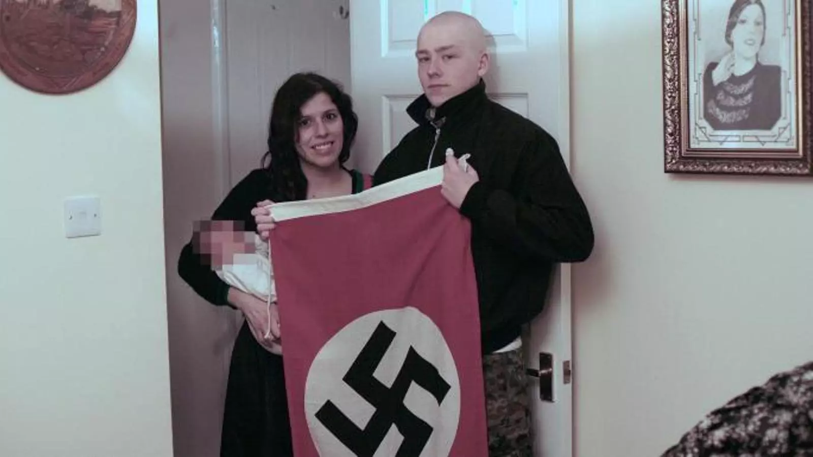 Els dos joves amb la criatura mostrant una bandera nazi
