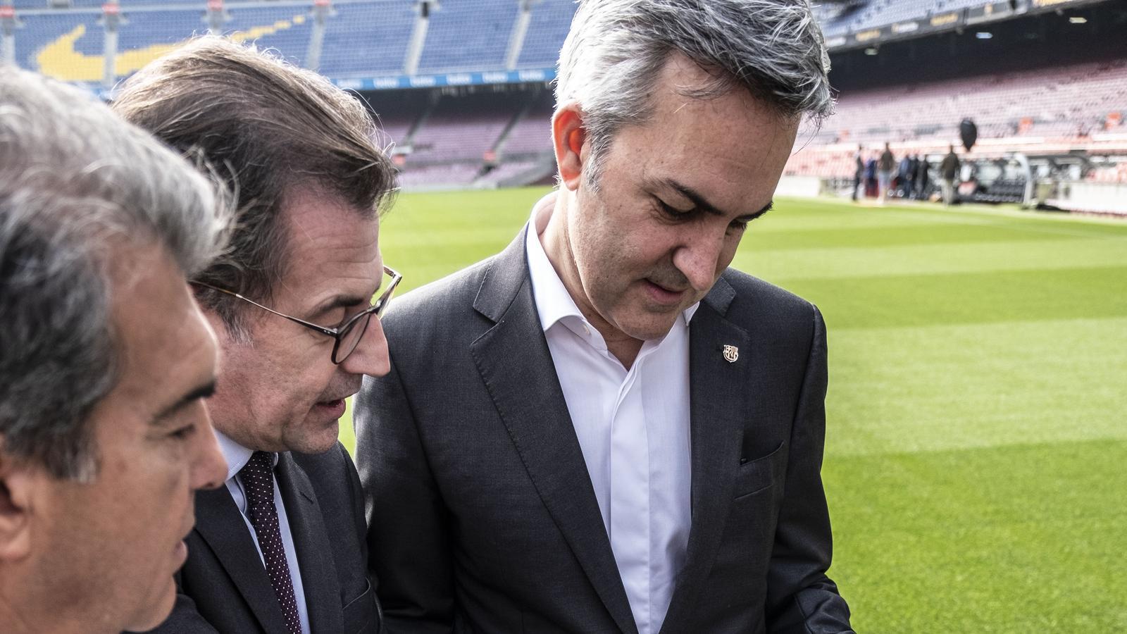 Joan Laporta, Toni Freixa i Víctor Font mirant les pàgines de l'ARA amb una fotografia de l'equip femení del Barça ocupant el pòster central.