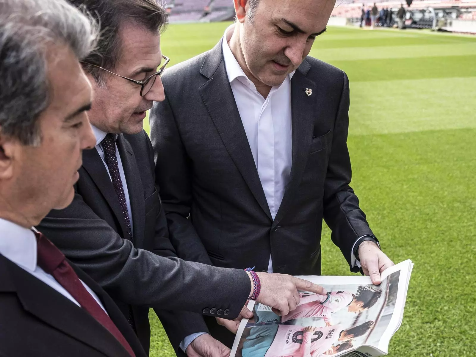 Joan Laporta, Toni Freixa i Víctor Font mirant les pàgines de l'ARA amb una fotografia de l'equip femení del Barça ocupant el pòster central.
