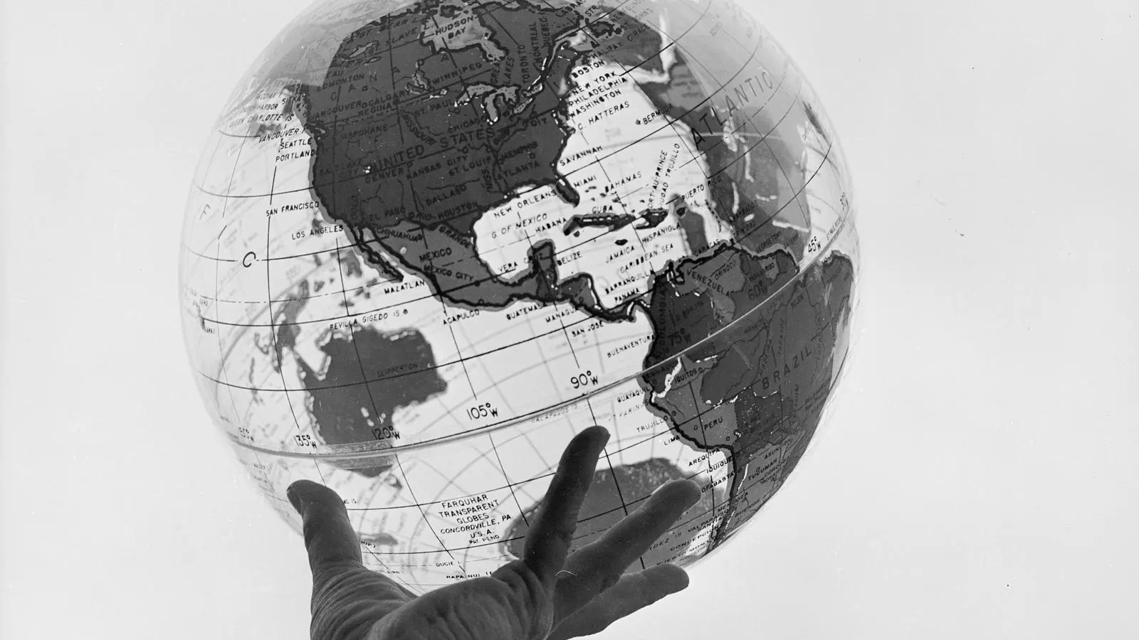 Una mà sostenint un globus terraqüi transparent