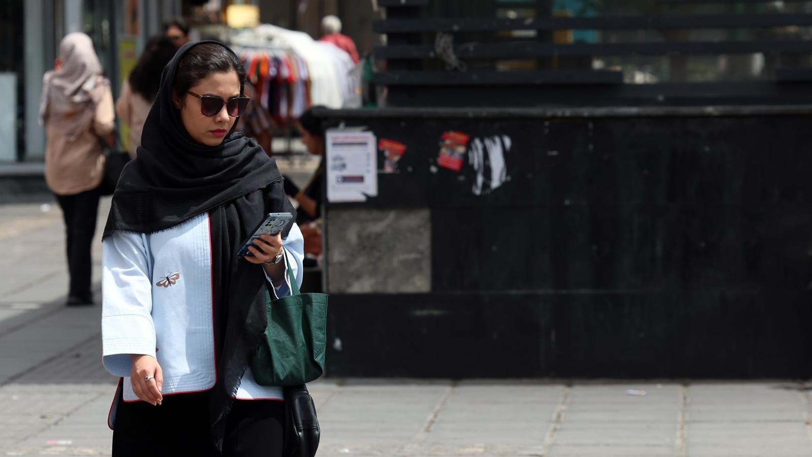 Una mujer consultando el teléfono en Teherán
