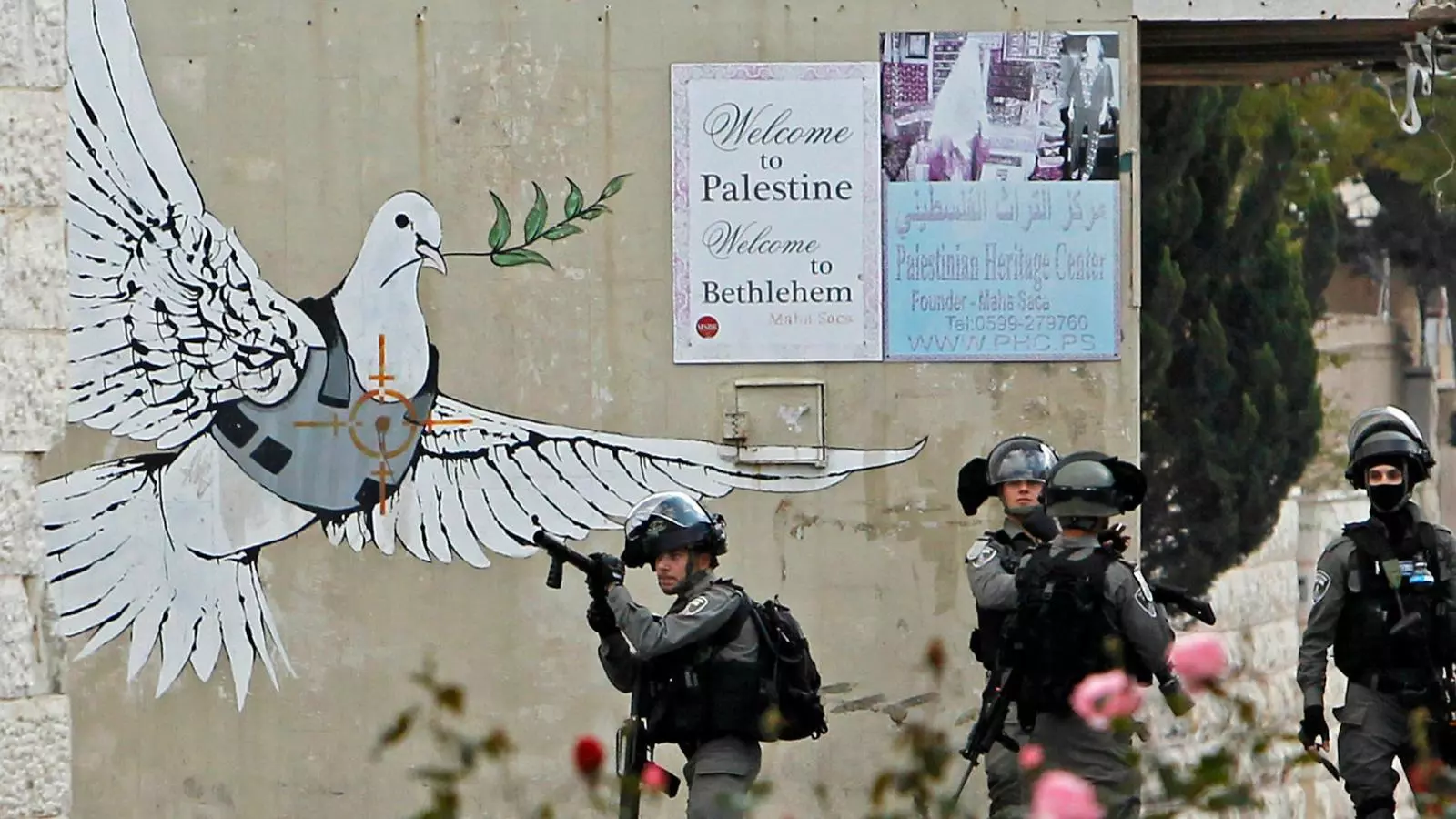 Des de fa més d’una dècada, Banksy viatja regularment a Betlem i fa pintades al mur que ha aixecat el govern israelià per aïllar la població de les noves colònies que hi construeix. Aquestes pintades, com la coneguda del colom amb armilla antibales, s’han convertit, de fet, en una atracció turística més de Betlem, tot i que en alguns casos ja estan molt deteriorades. Des del març passat, a més, ha decorat un hotel. A sobre, imatge de la suite del The Walled Off Hotel, i a sota l’entrada de l’establiment.