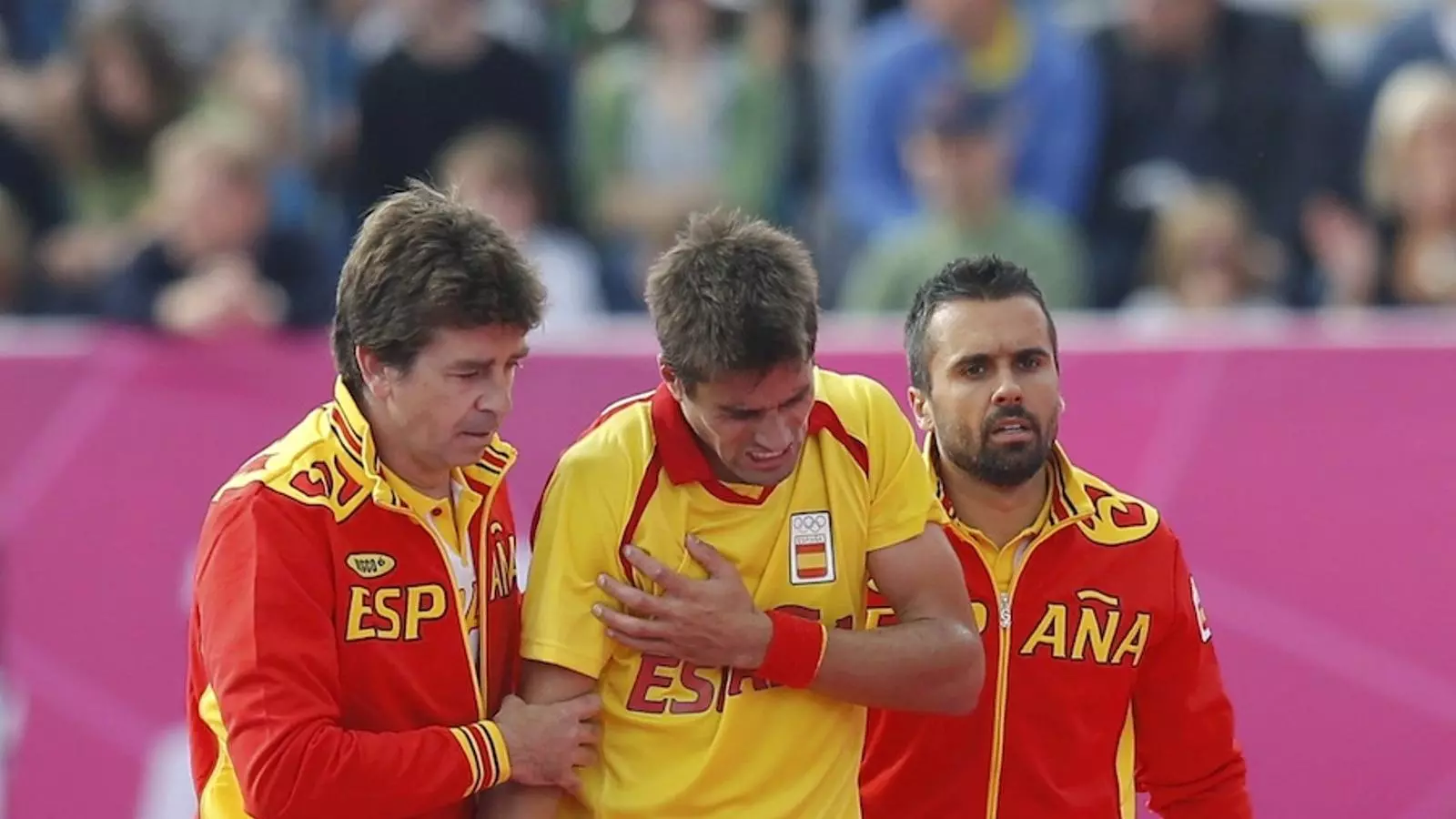 Pol Amat, al centre, atès pels metges després de lesionar-se a l'espatlla en el partit d'hoquei herba