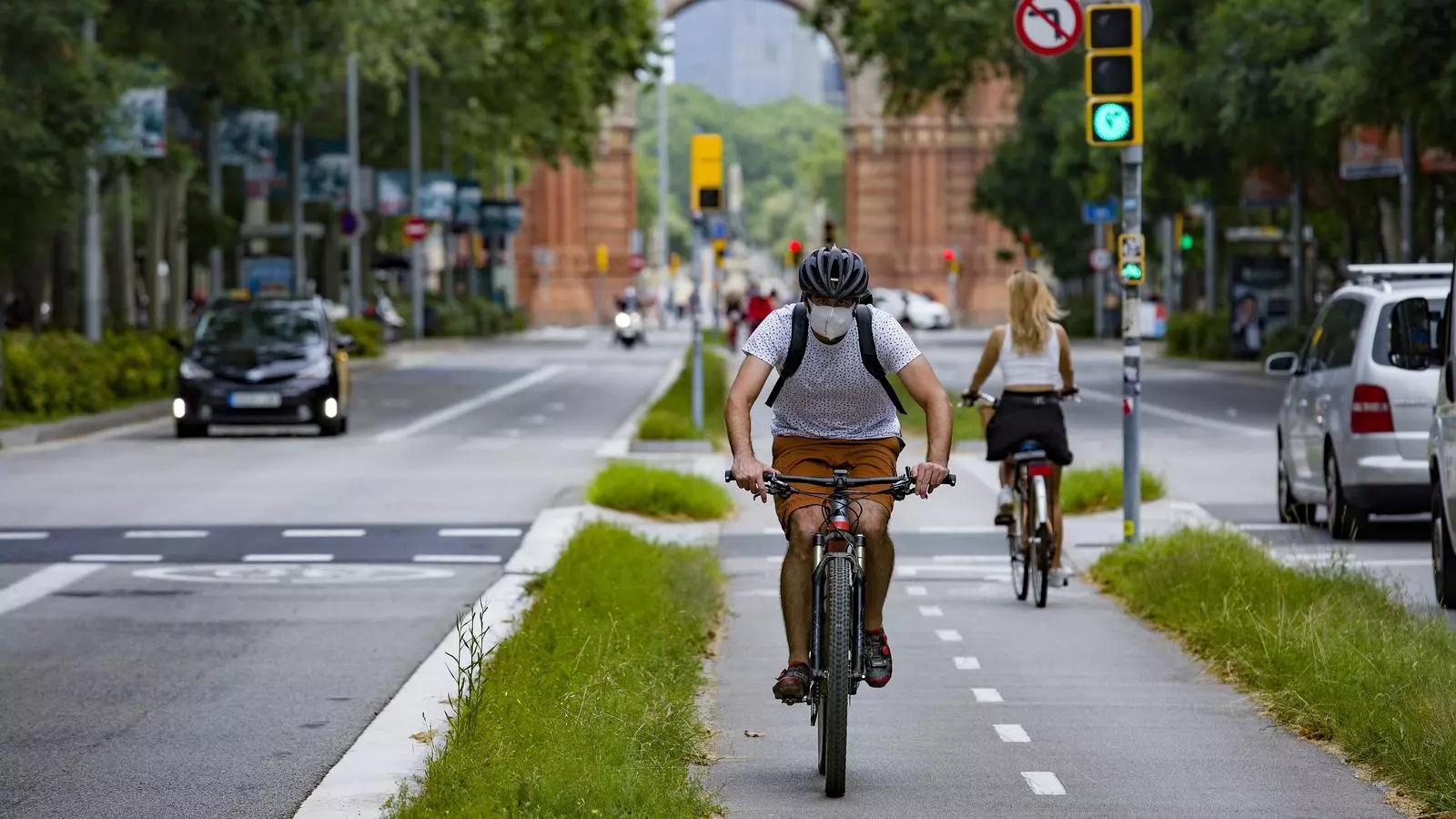 Un noi circula en bicicleta i mascareta pel Passeig Sant Joan de Barcelona