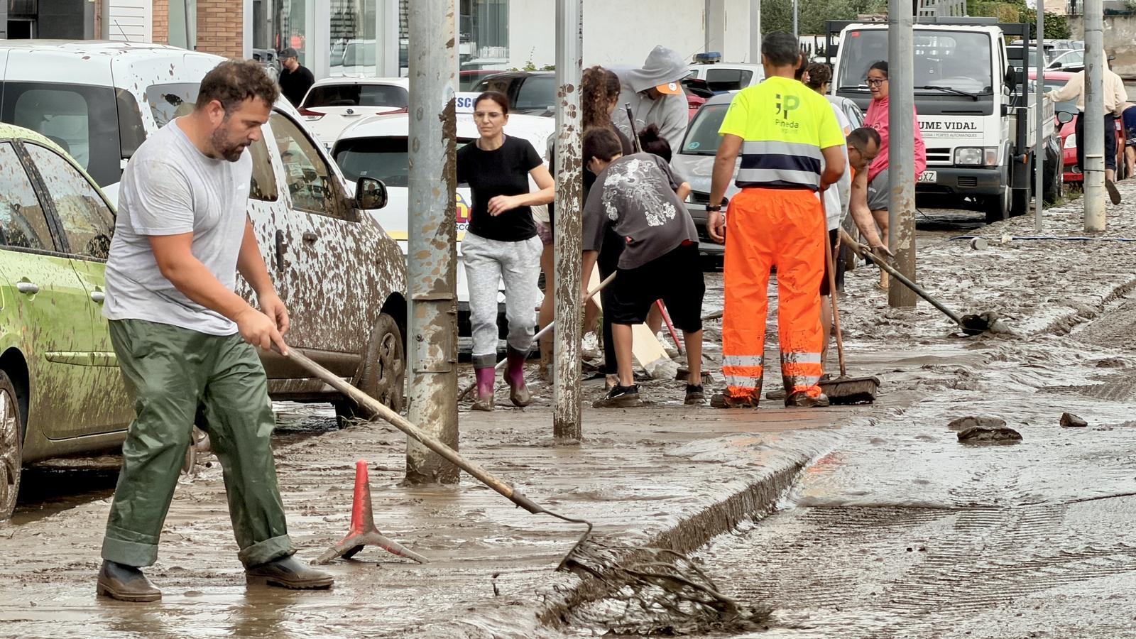 Vecinos limpiando en Pineda de Mar las afectaciones de las lluvias torrenciales en la zona de la N-2.