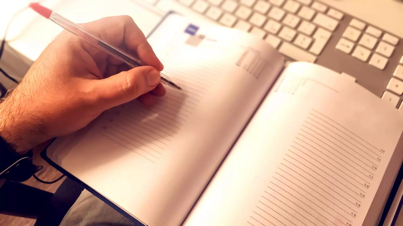 Un home escriu en una agenda
