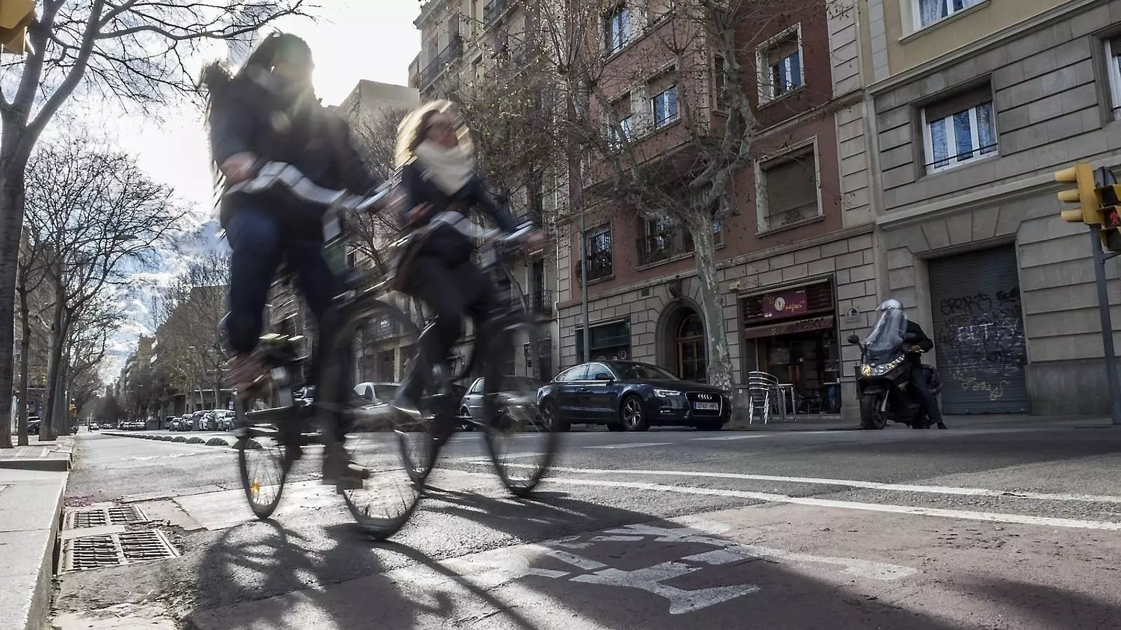 Dues noies en bicicleta pel carrer Consell de Cent
