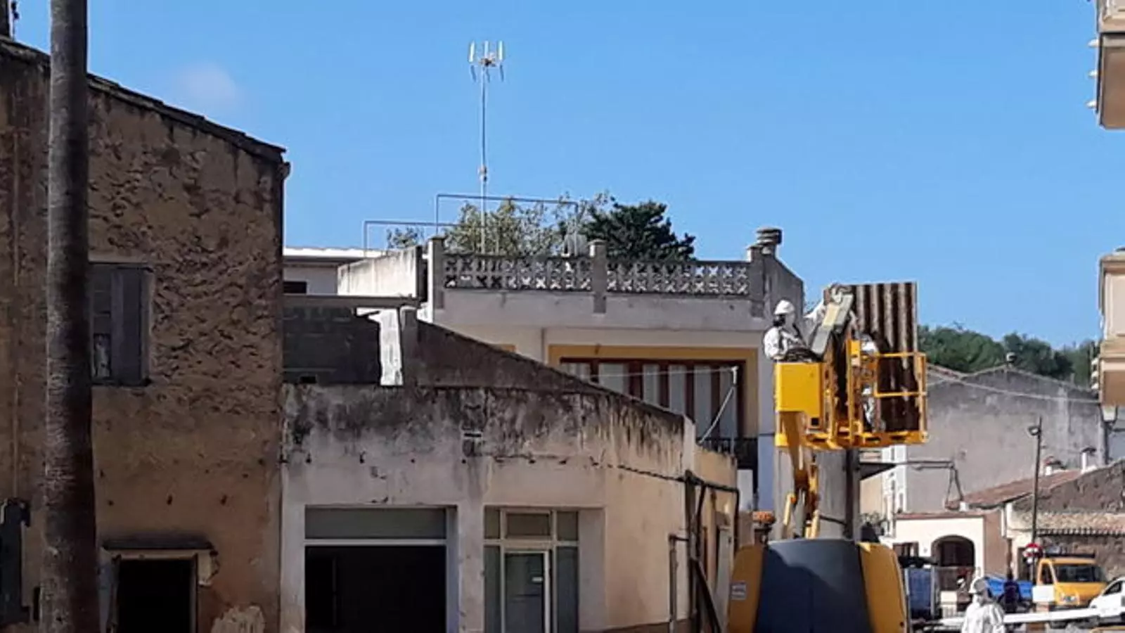 Una grua treballa en les obres d'enderrocament d'una de les cases més afectades
