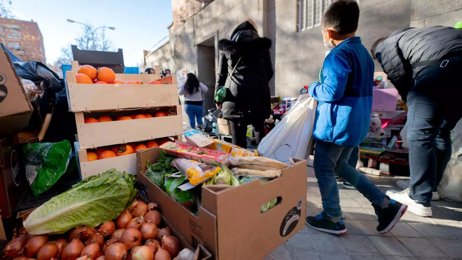 Persones en risc d'exclusió acudeixen a recollir aliments.