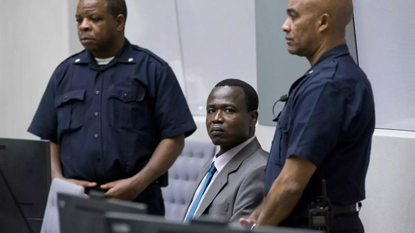 Ongwen, assegut entre dos guàrdies, espera l'inici de la vista oral al TPI de l'Haia.