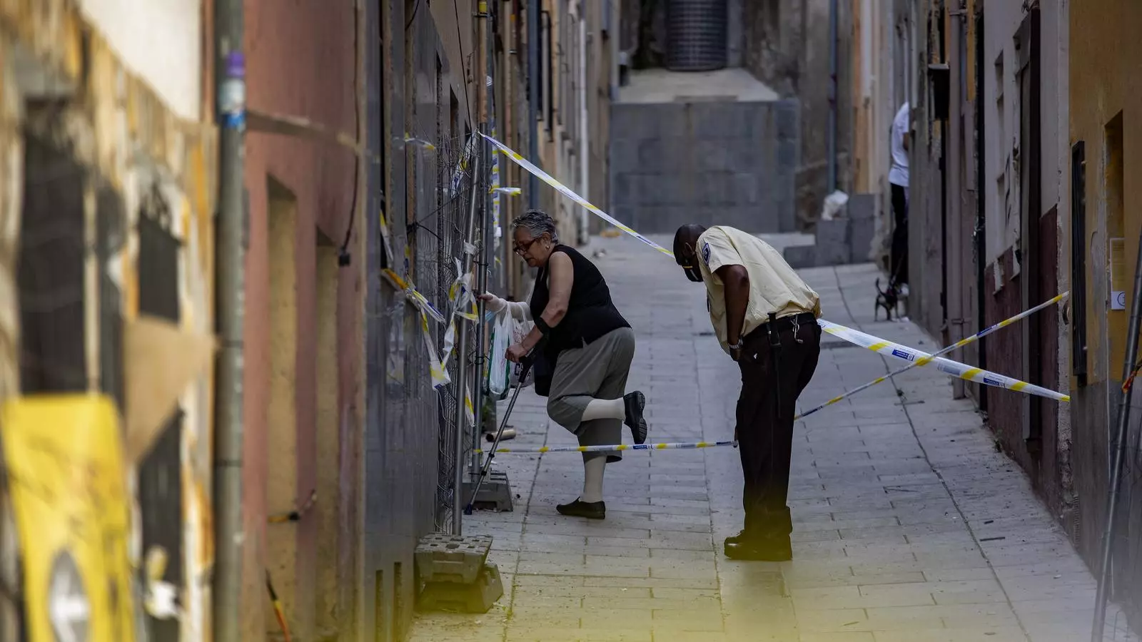 Un treballador de seguretat acompanyant una veïna al passatge de Sigüenza