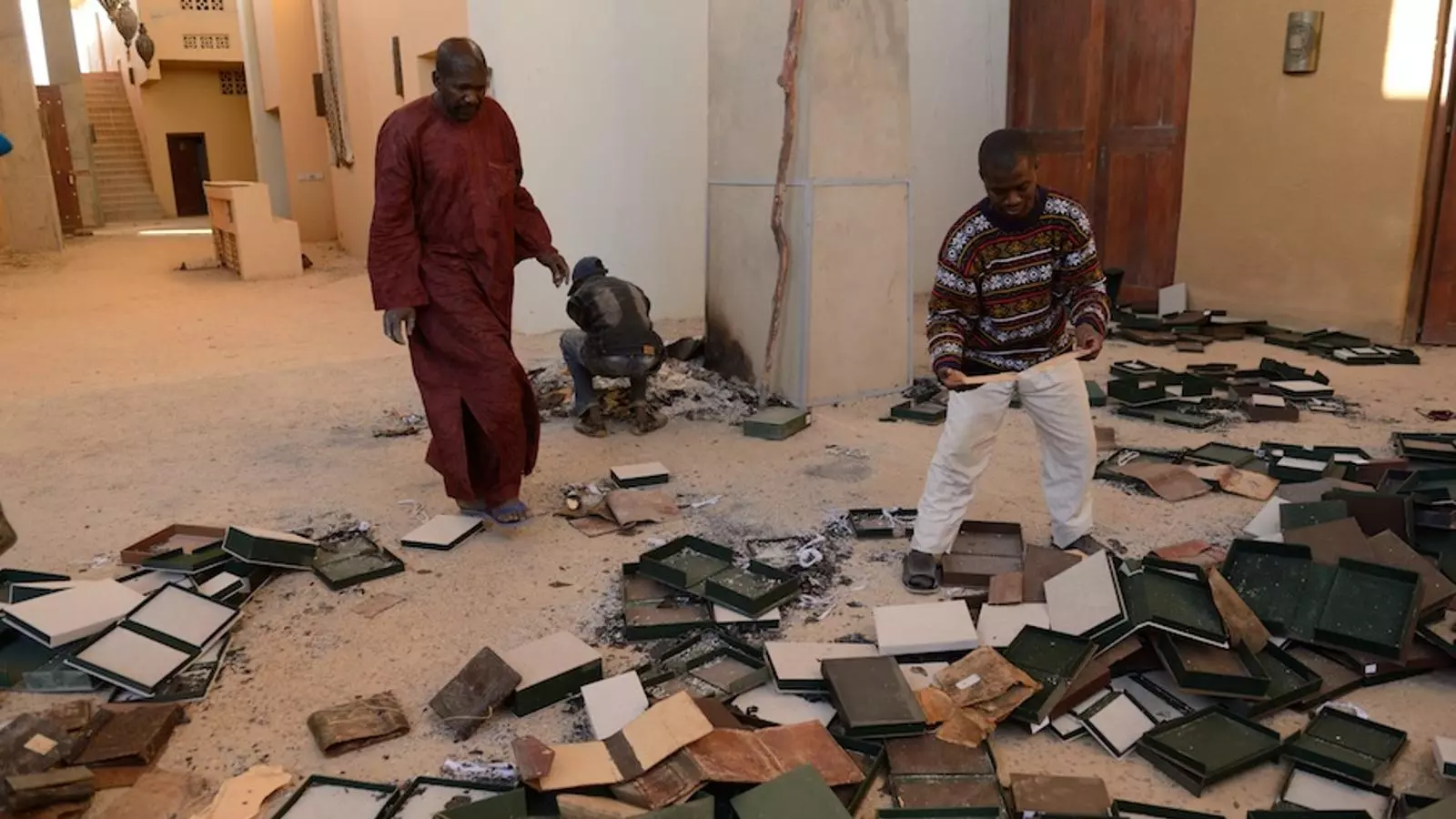 Uns homes recuperen part dels manuscrits danyats dilluns, en l'incendi de l'Institut Ahmed Baba de Tombouctou / ERIC FEFERBERG / AFP