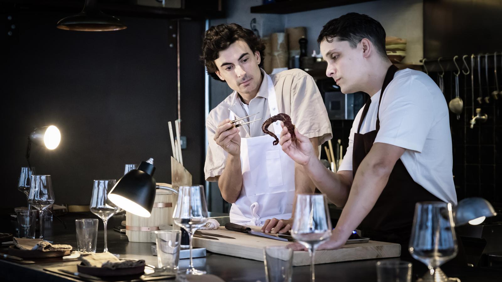 Alex Vall y Jordi Paz con una pata de pulpo roquero de Blanes en la cocina y barra del restaurante Umo Àlex Vall en Barcelona.