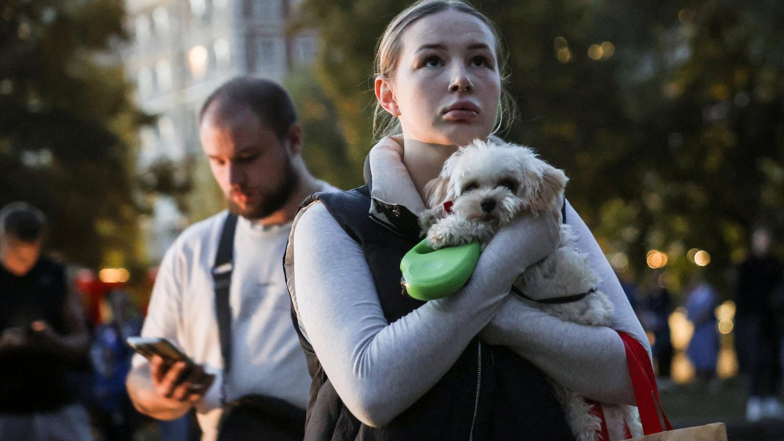 A girl with her pet after being a victim of one of the Russian bombings against Kyiv.