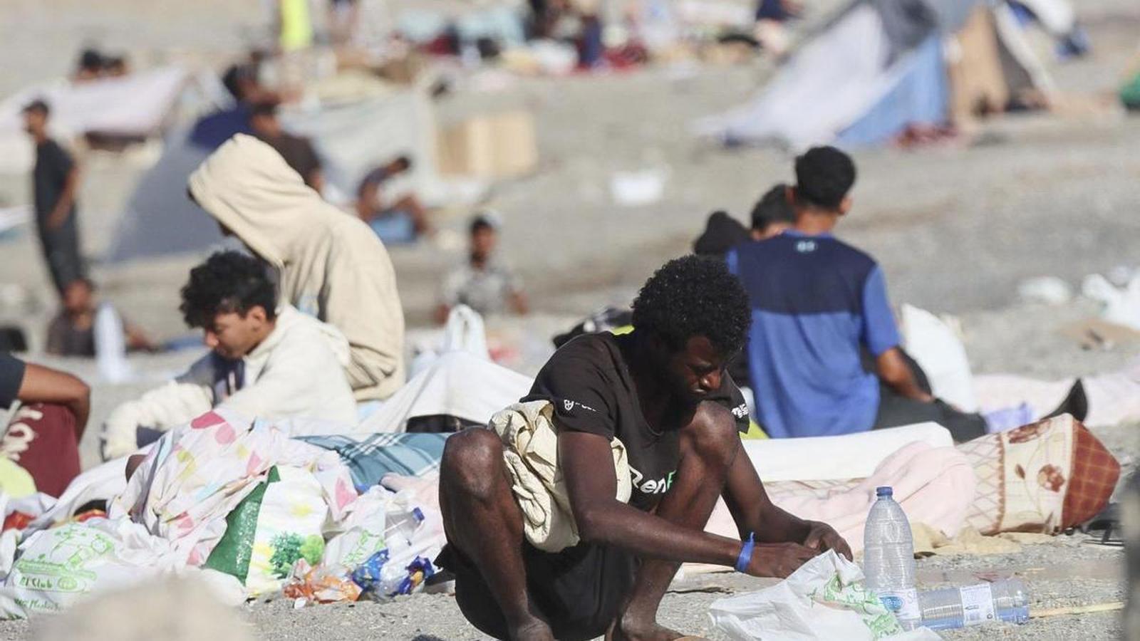 Migrantes en la playa de El Trampolín, en Ceuta, donde cientos de personas continúan acampadas a pesar de los diferentes desalojos policiales