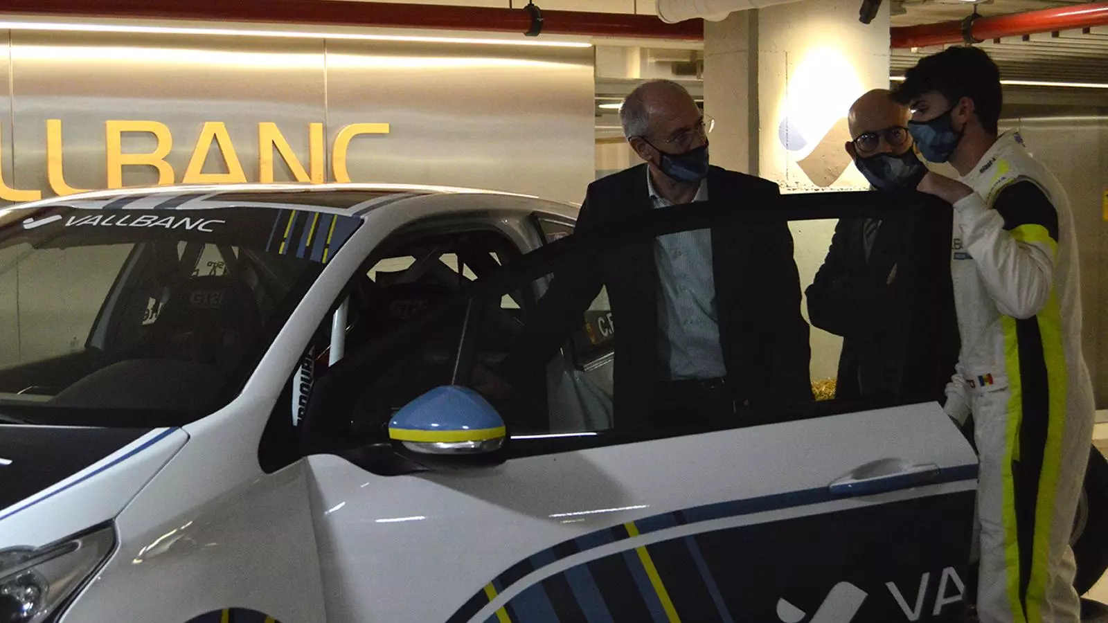 El pilot Àlex Español mostra el vehicle al director general de negoci de Vall Banc, Sergi Martín, i al director general de Vall Banc, José Luís Dorado.