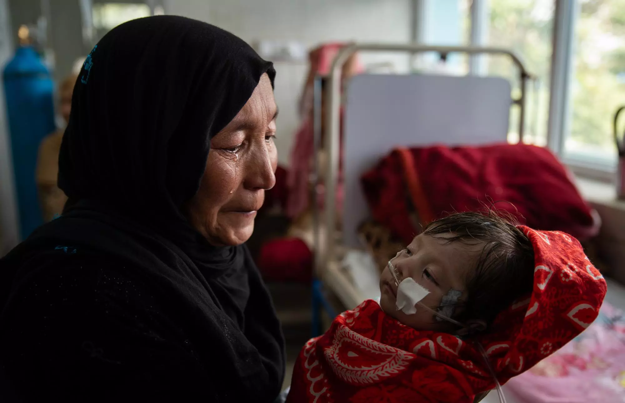 Una dona plora mentre un nen rep un tractament per desnutrició a l'hospital d'Indira Gandhi a Kabul