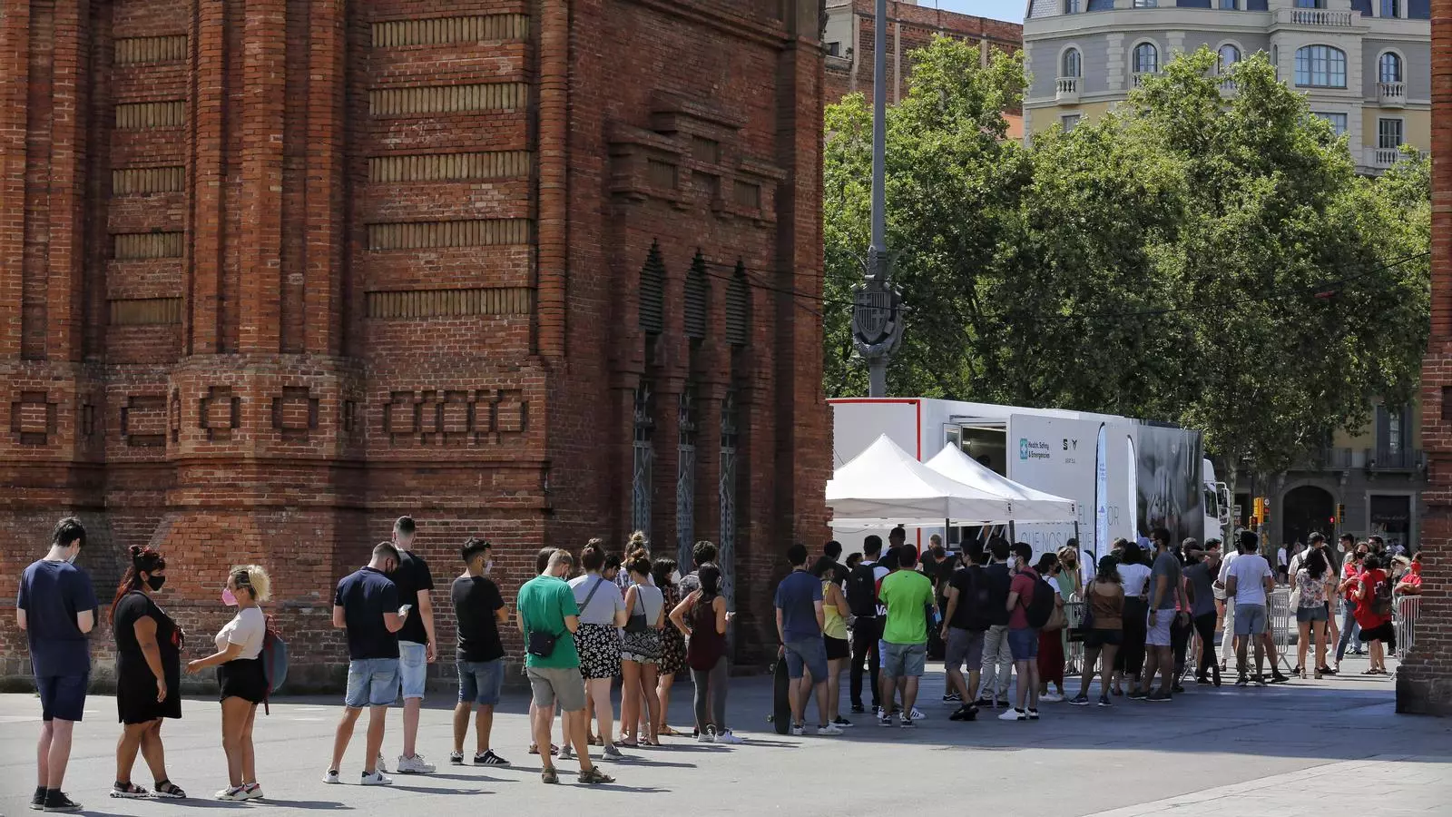 Diverses persones fan cua a l'autobús de l'Arc de Triomf on es vacuna tothom qui ho vulgui sense cita prèvia.