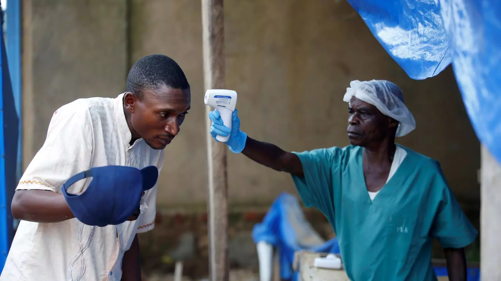 Un sanitari pren la temperatura a un pacient d'Ebola, en un centre de tractament a la ciutat congolesa de Beni, en una imatge d'arxiu
