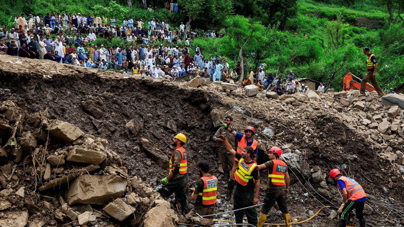 Residents of Dalori Bala watch emergency teams search.