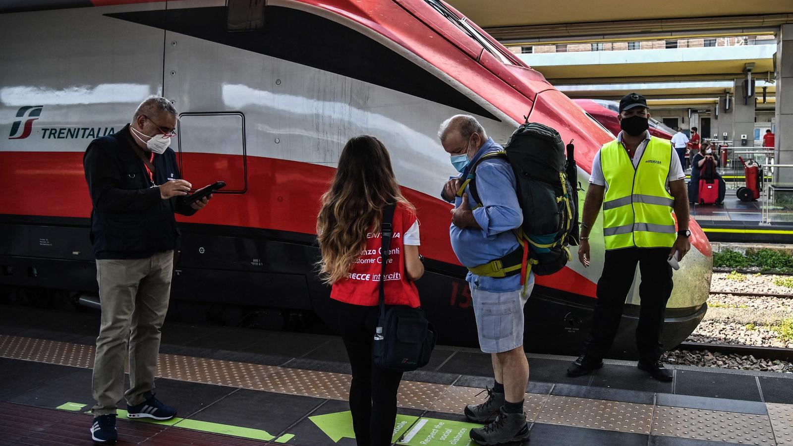 Un inspector comprova el passaport covid d'un passatger que puja a un tren d'alta velocitat aquest dimecres a l'estació de Porta Nuova, a Torí.