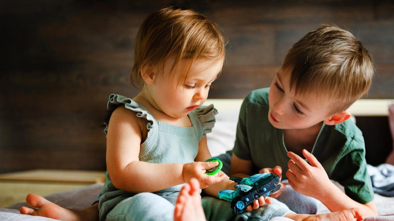 Two children playing with a single toy.