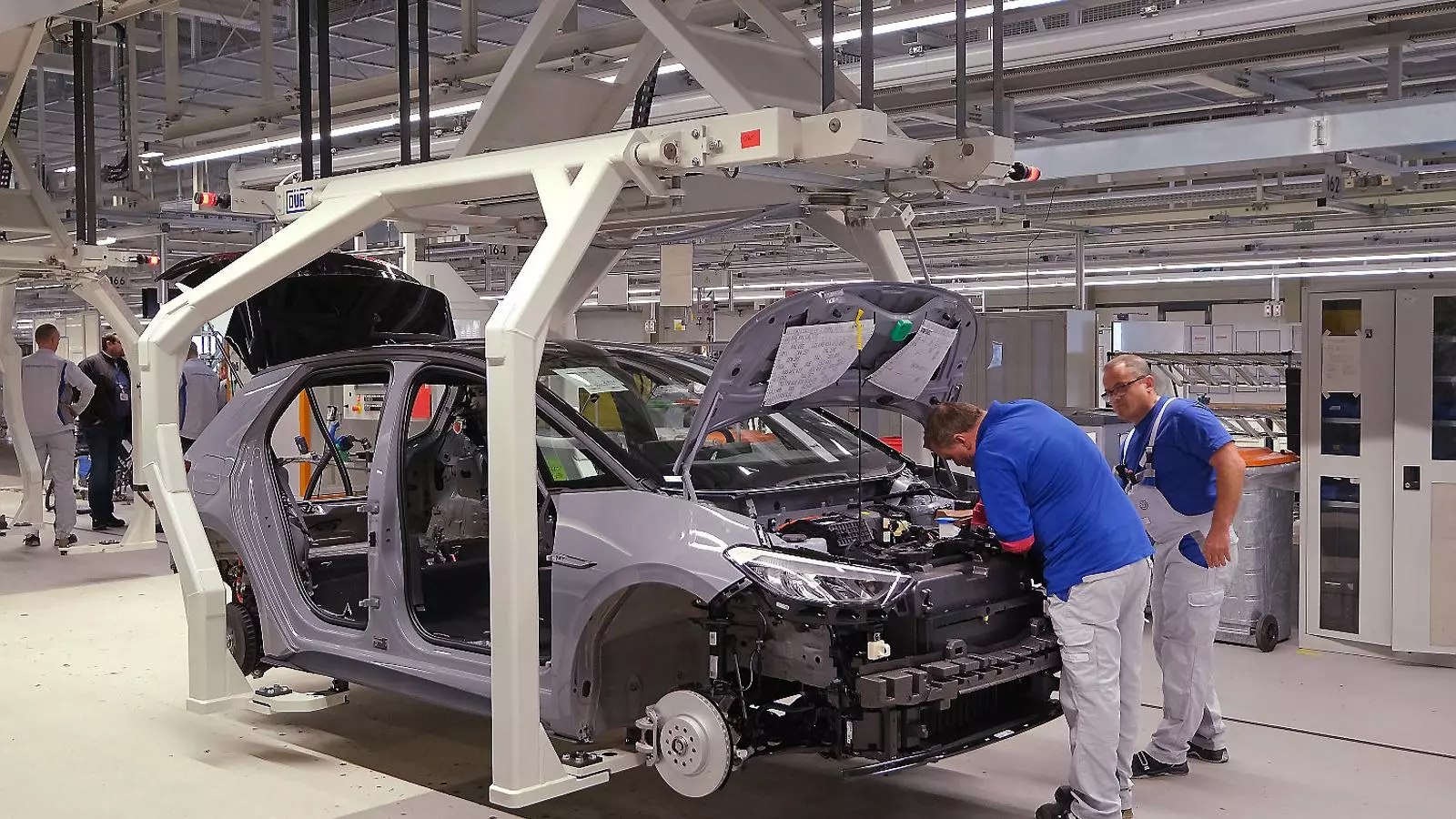 Empleats trabajando en un coche eléctrico en la fábrica de Volkswagen a Zwickau (Alemania).