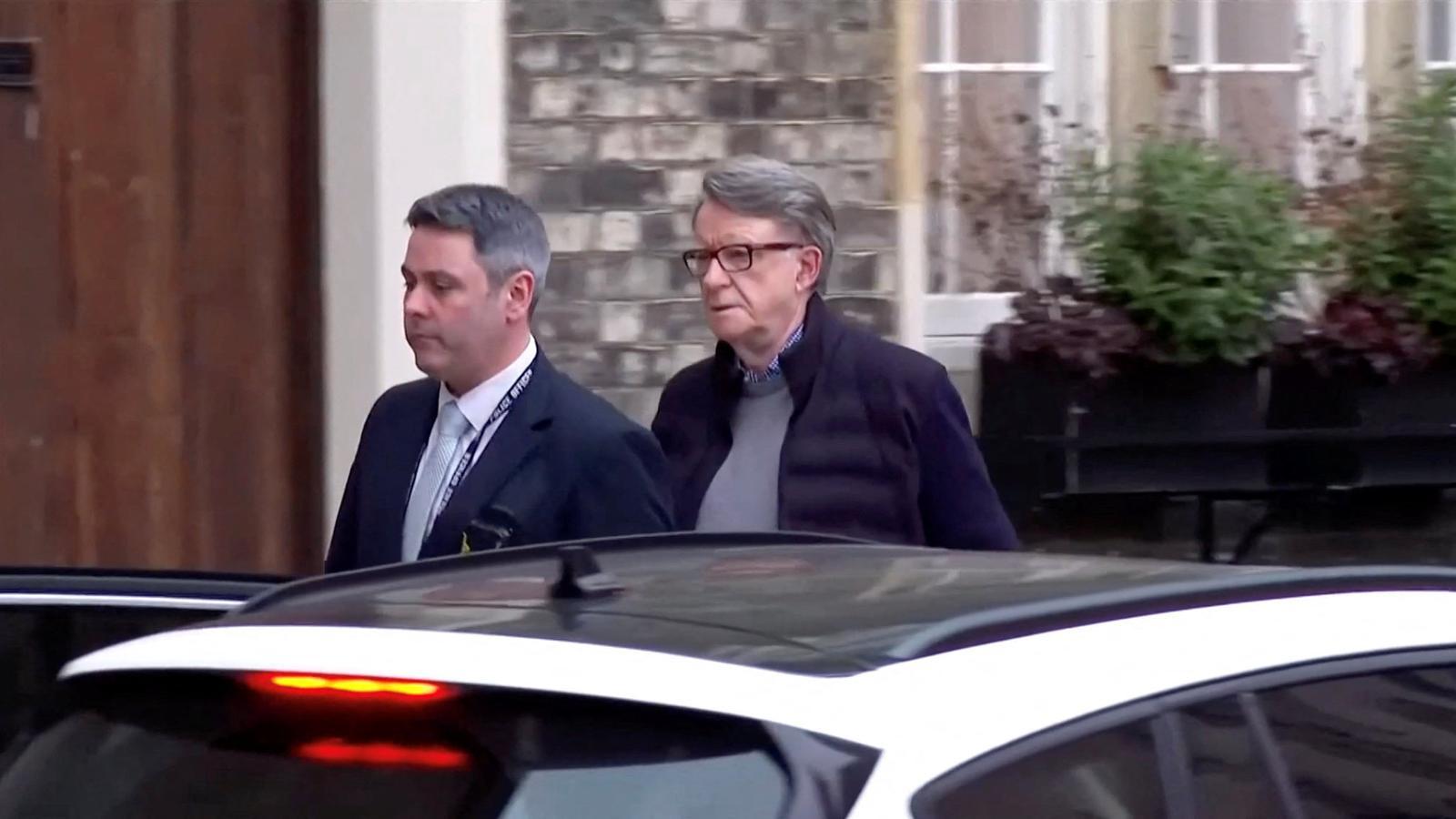 Peter Mandelson, a la dreta, aquest dilluns a la tarda, conduït per un policia per ser interrogat despré del seu arrest.