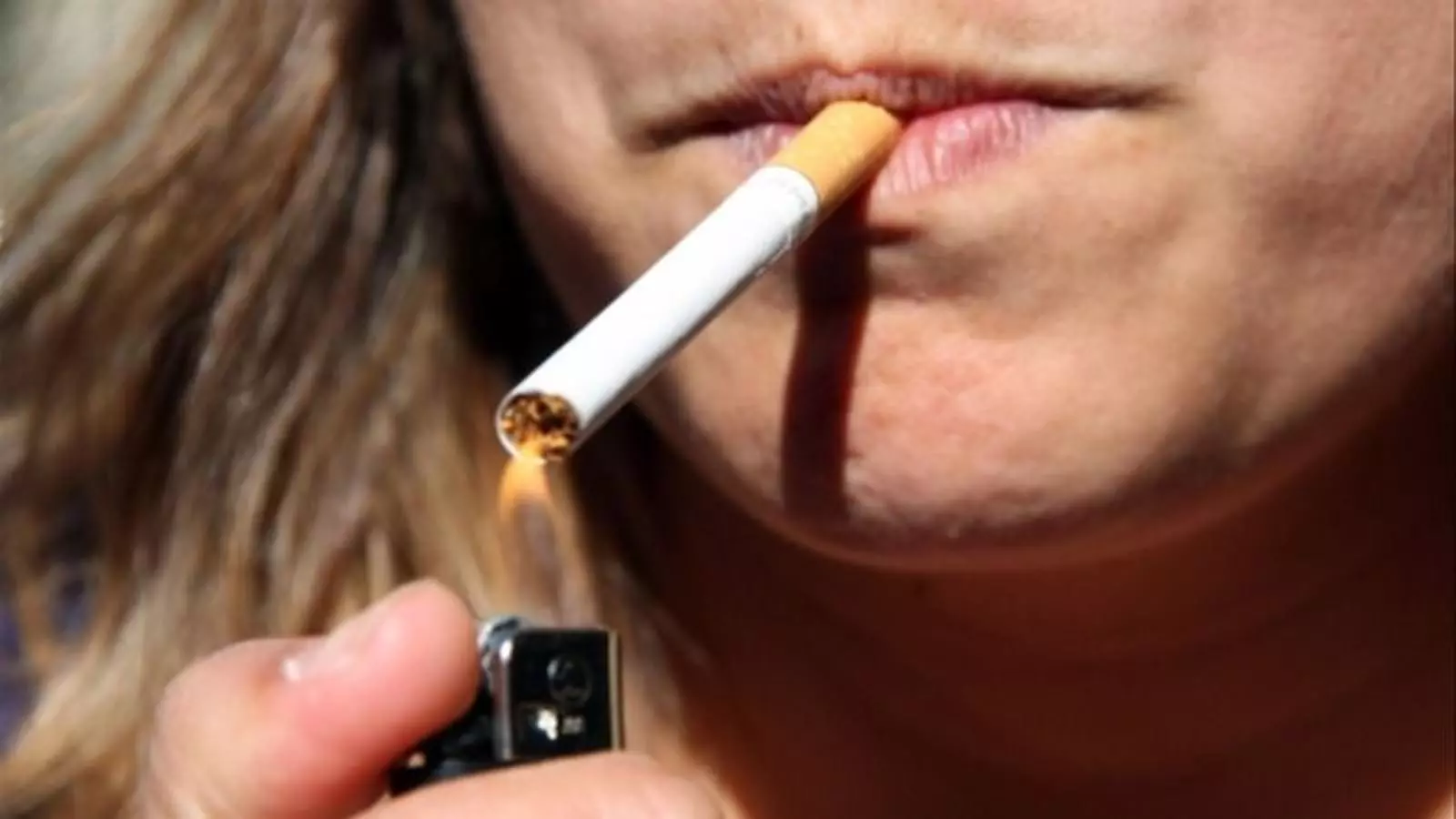 Una dona encenent un cigarret en una imatge d'arxiu.