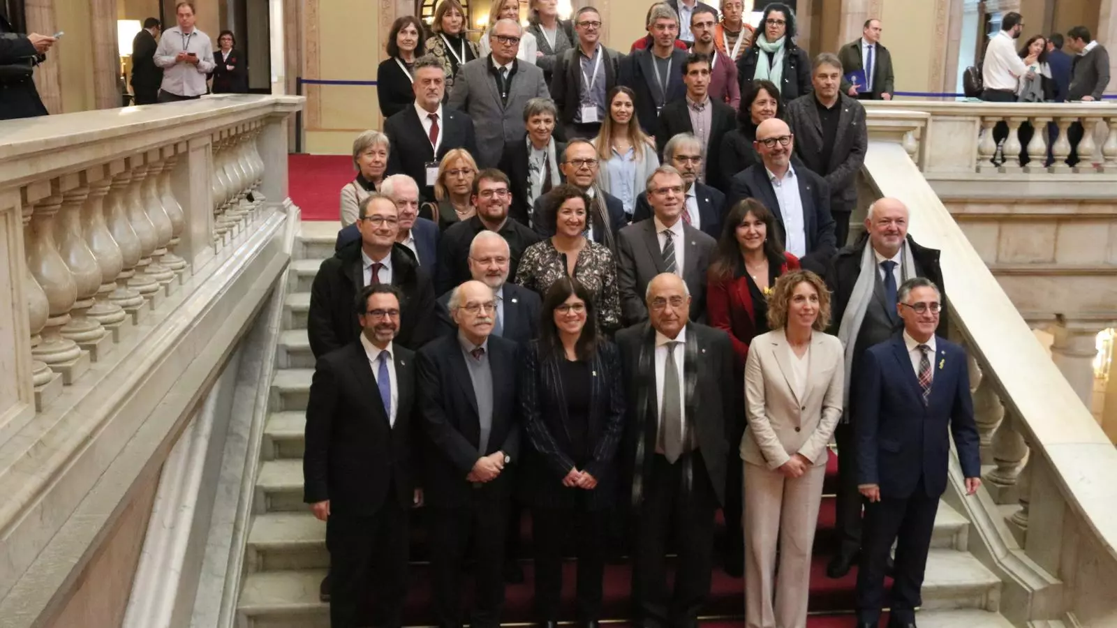 El conseller Quim Nadal, ponents i relators de la llei de la Ciència, i representants dels grups parlamentaris, a l'escala honorífica de la cambra després d'aprovar-se la normativa.