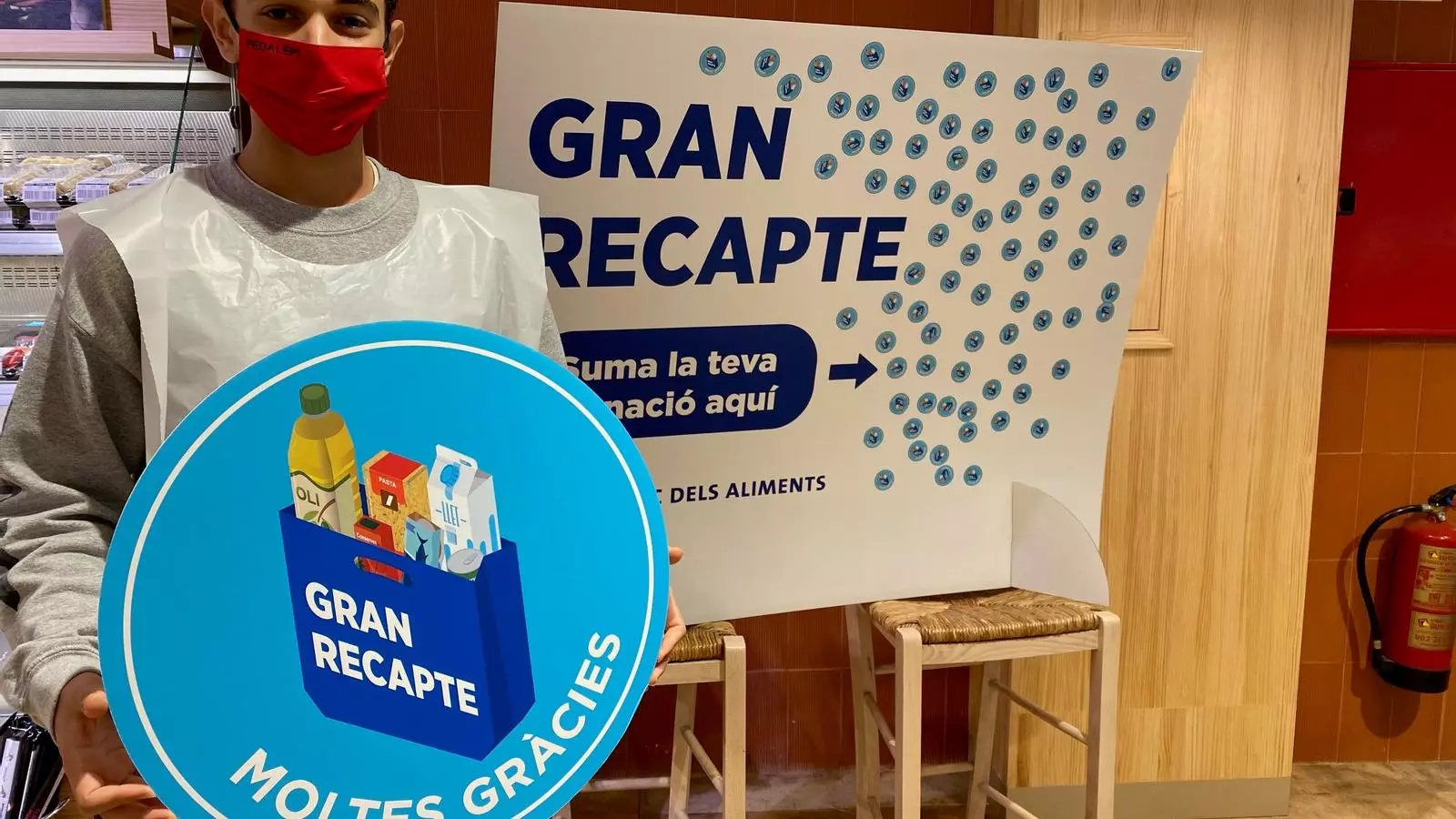 Un voluntari amb cartelleria del Gran Recapte