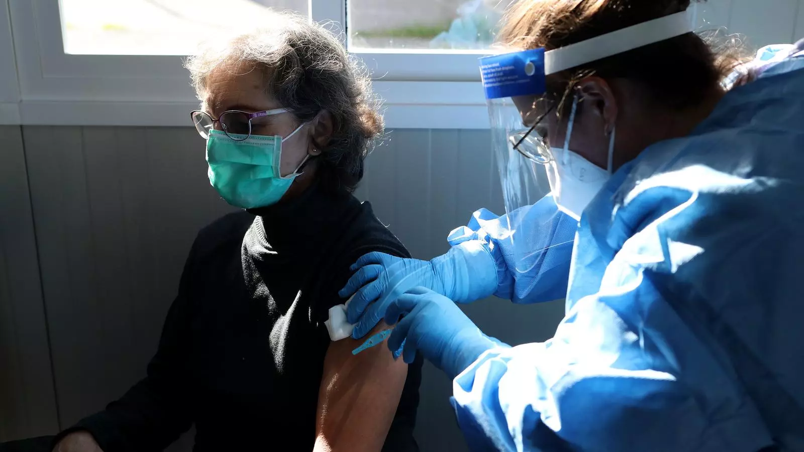 Moment en què una sanitària administra la vacuna contra el covid-19