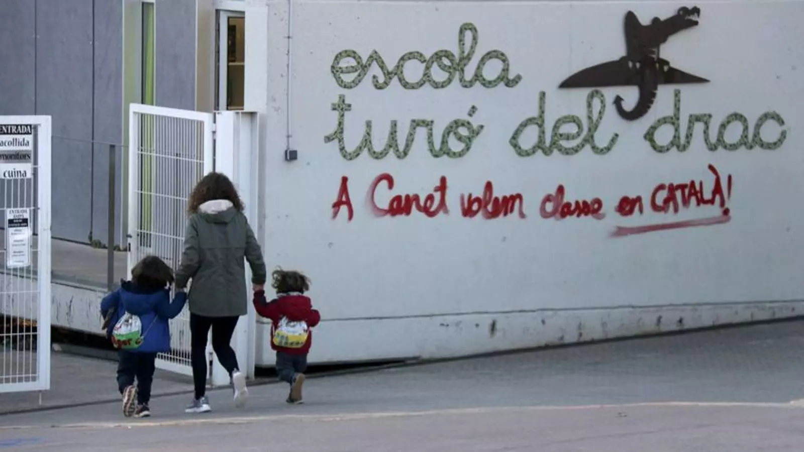 Una mare acompanyant els seus fills a l'escola Turó del Drac de Canet de Mar.