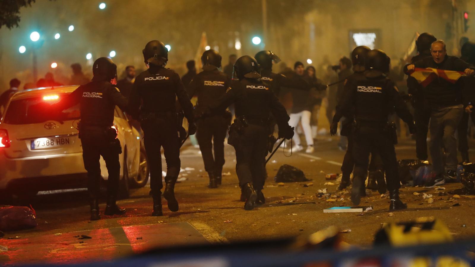 Agents de la Policia Nacional intervenen durant la concentració d'aquest dilluns davant de la seu del PSOE al carrer Ferraz