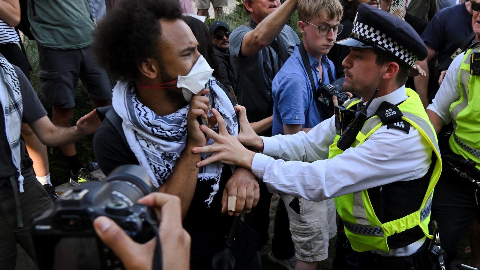 An officer pushes one of the protesters who took part in the demonstration in London.