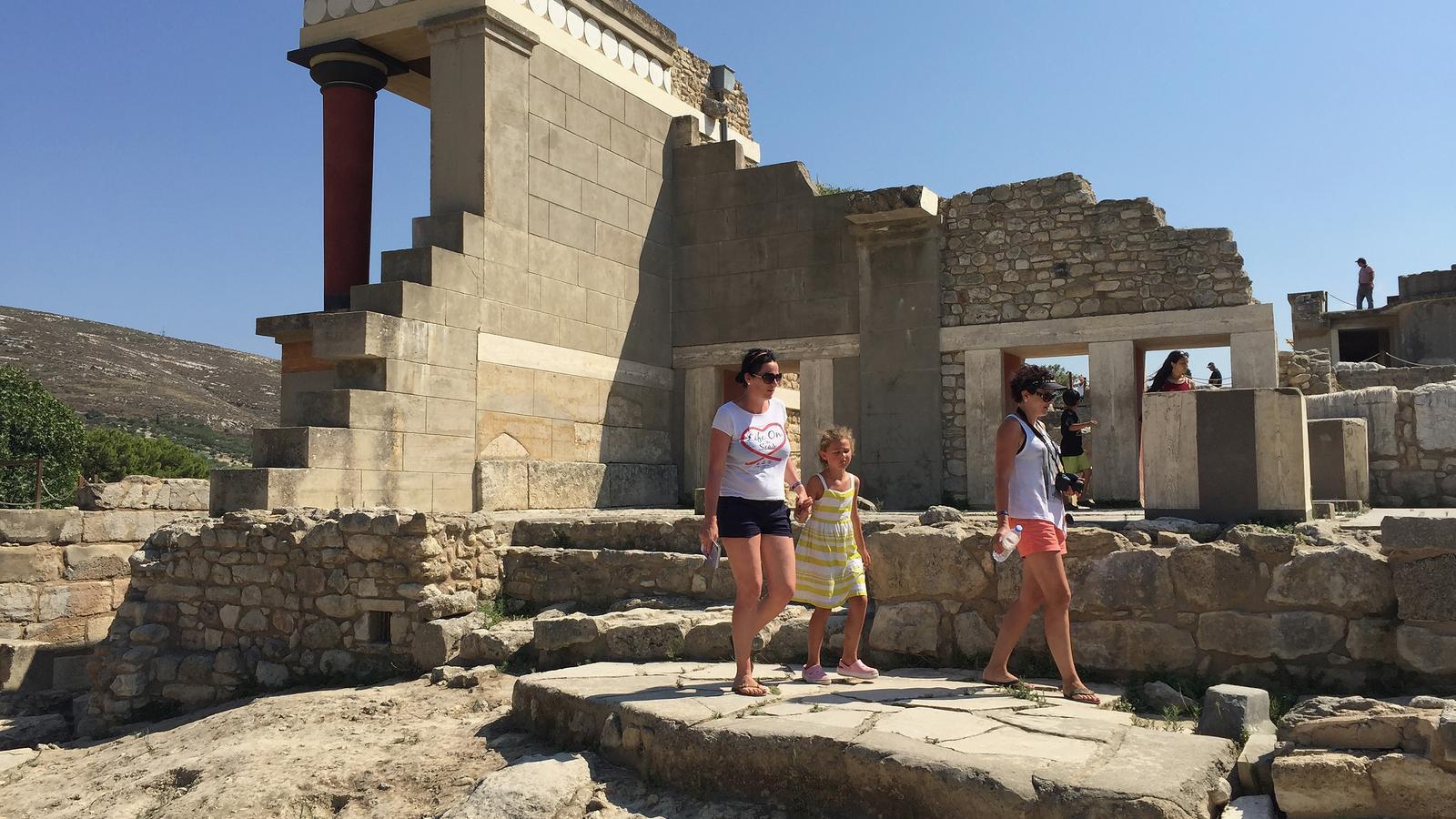 Visitors among the partially reconstructed ruins of the ancient Minoan city of Knossos on the island of Crete