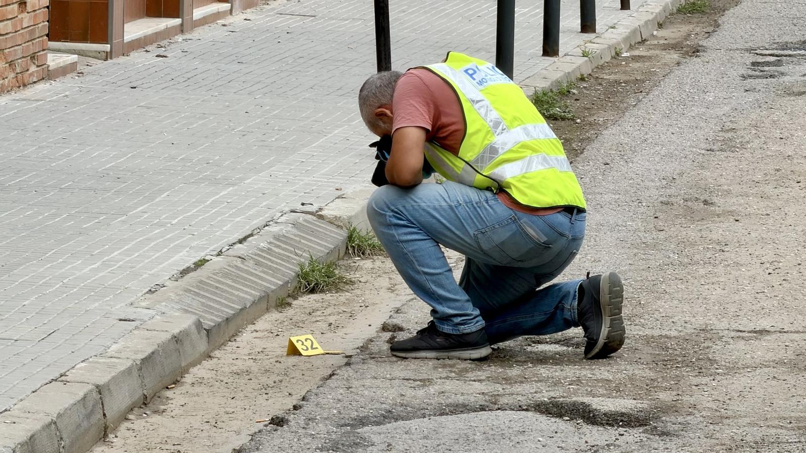 A Mossos agent photographs a shell casing after the shooting on Europa Street in Terrassa.