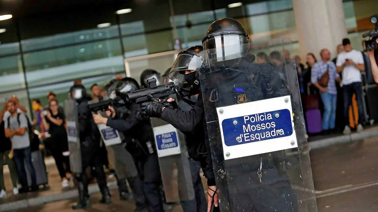 Un agent dels Mossos apuntant amb una pistola d’escuma en l’actuació del 14 d'octubre a l’aeroport del Prat