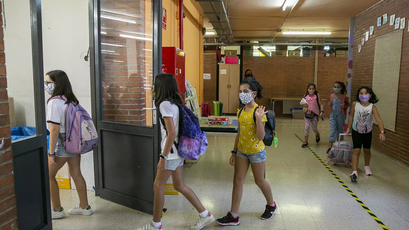 Un grup d'alumnes entrant a l'aula amb mascareta