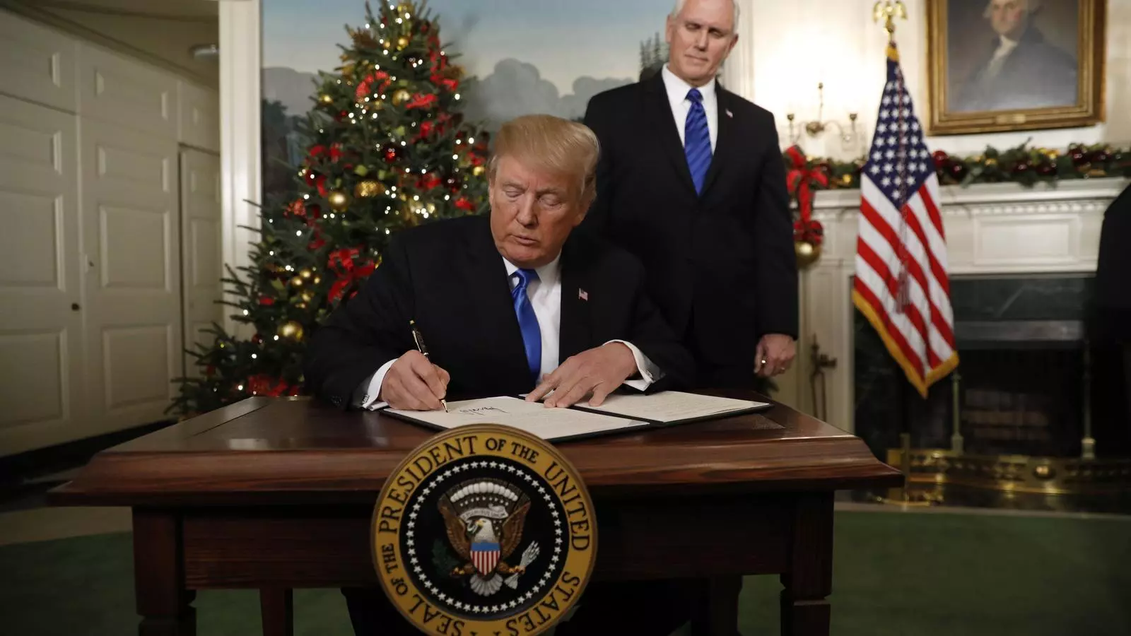 El vicepresident dels EUA, Mike Pence (a la dreta de la imatge) observa com Donald Trump signa la seva polèmica decisió respecte la ciutat de Jerusalem