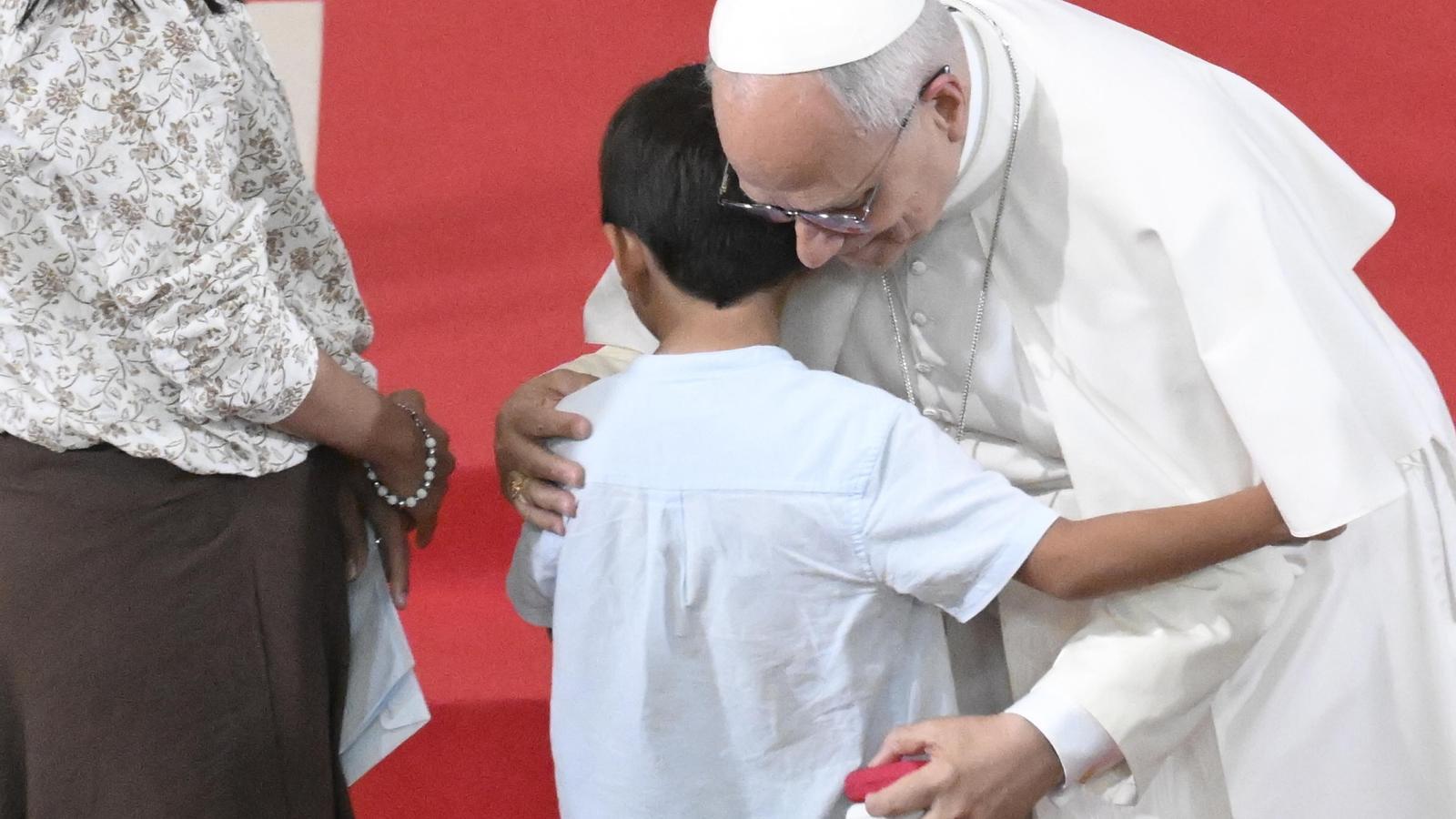 The Pope embracing Renzo, a six-year-old boy from Raval, at the parish of Sant Agustí.