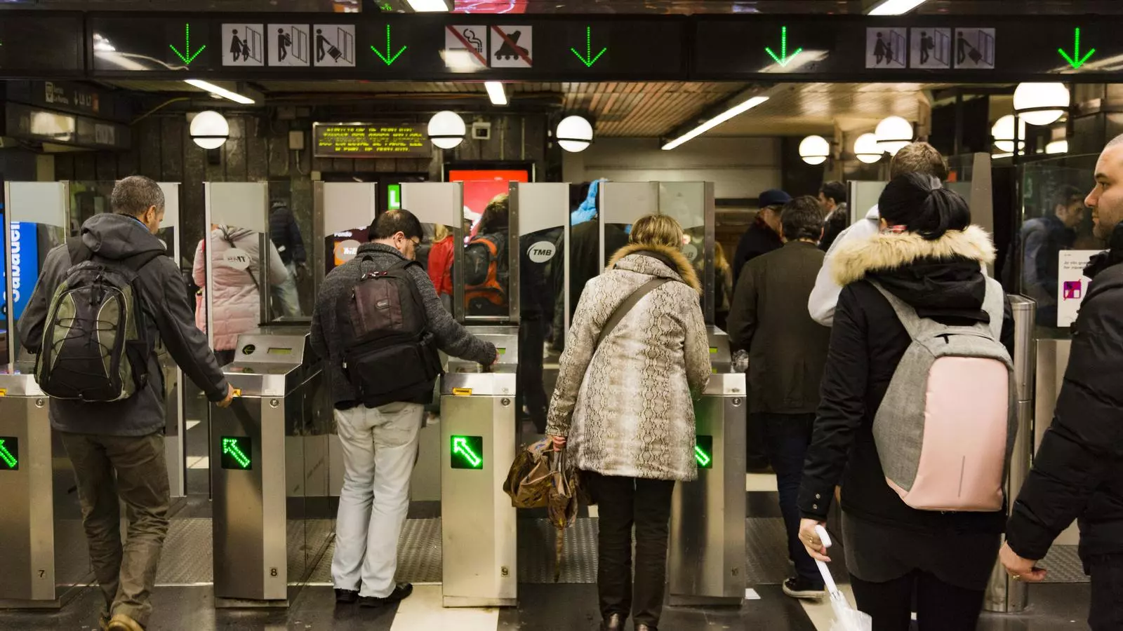 Usuaris del transport públic entrant a l'estació de metro de Plaça Catalunya