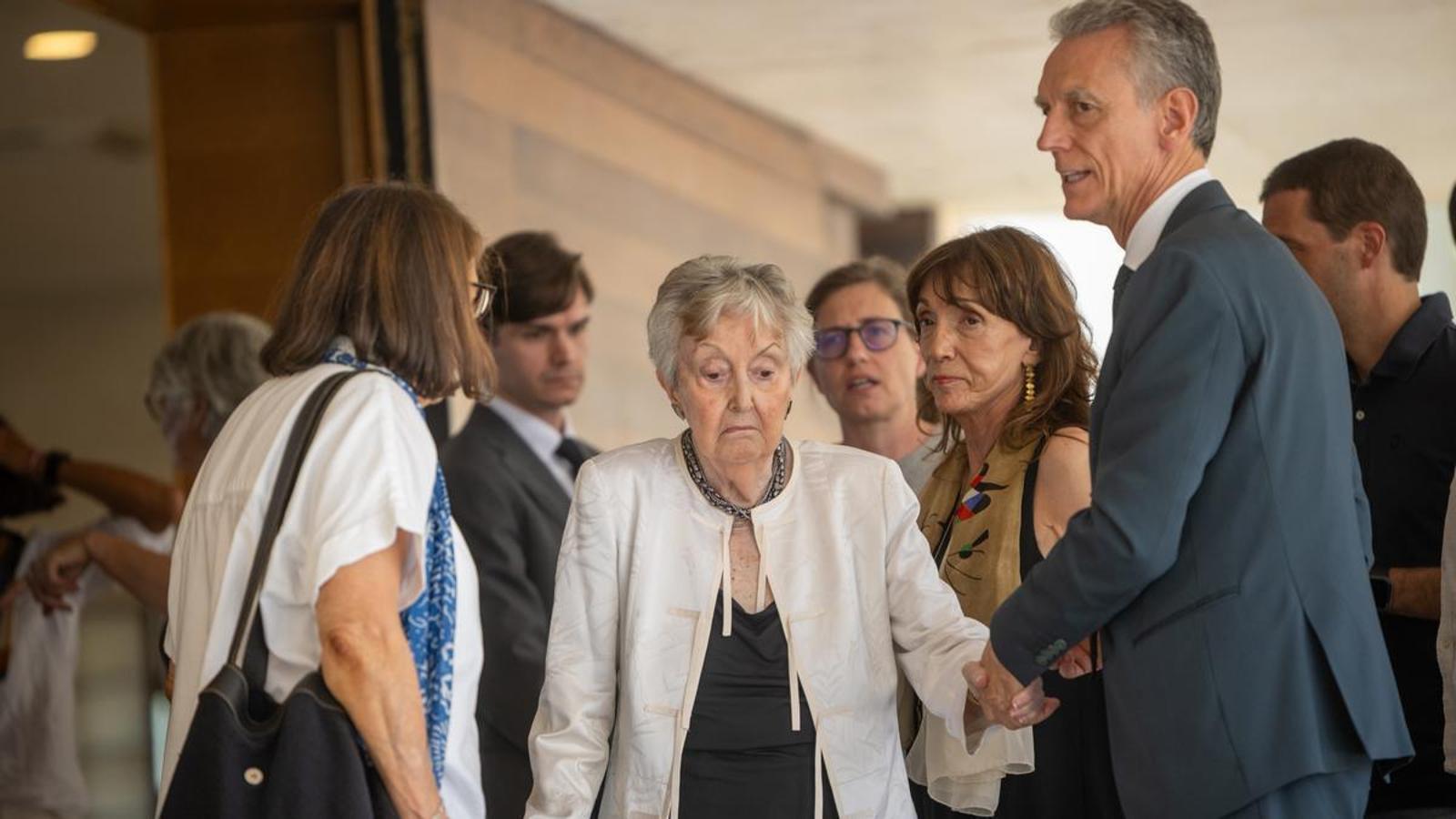 Lola Mitjans, viuda de Josep Vilarasau, acompañada de familiares a la salida del funeral de su marido, este jueves en Barcelona.